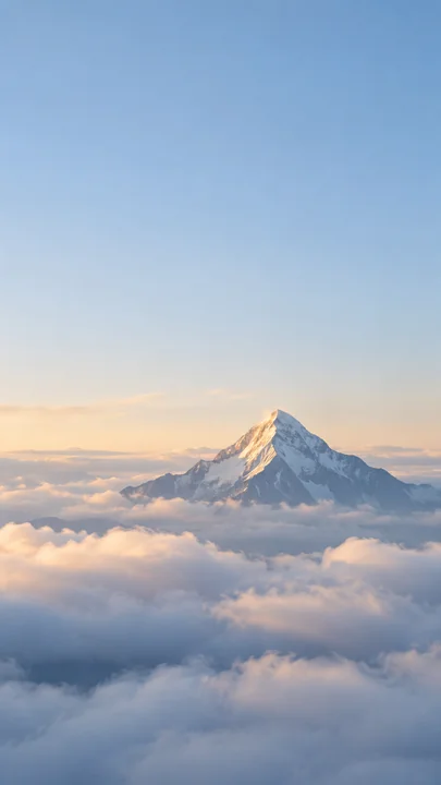晨光轻落在雪峰的一侧，蓝灰山影从柔软云海中浮现，大面积晴空留下安静的锁屏空间。，手机壁纸
